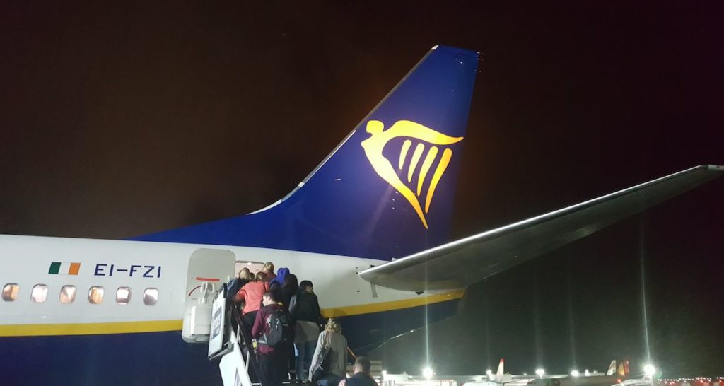 people boarding an airplane at night