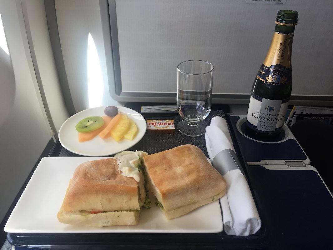 a sandwich and fruit on a plate on a tray