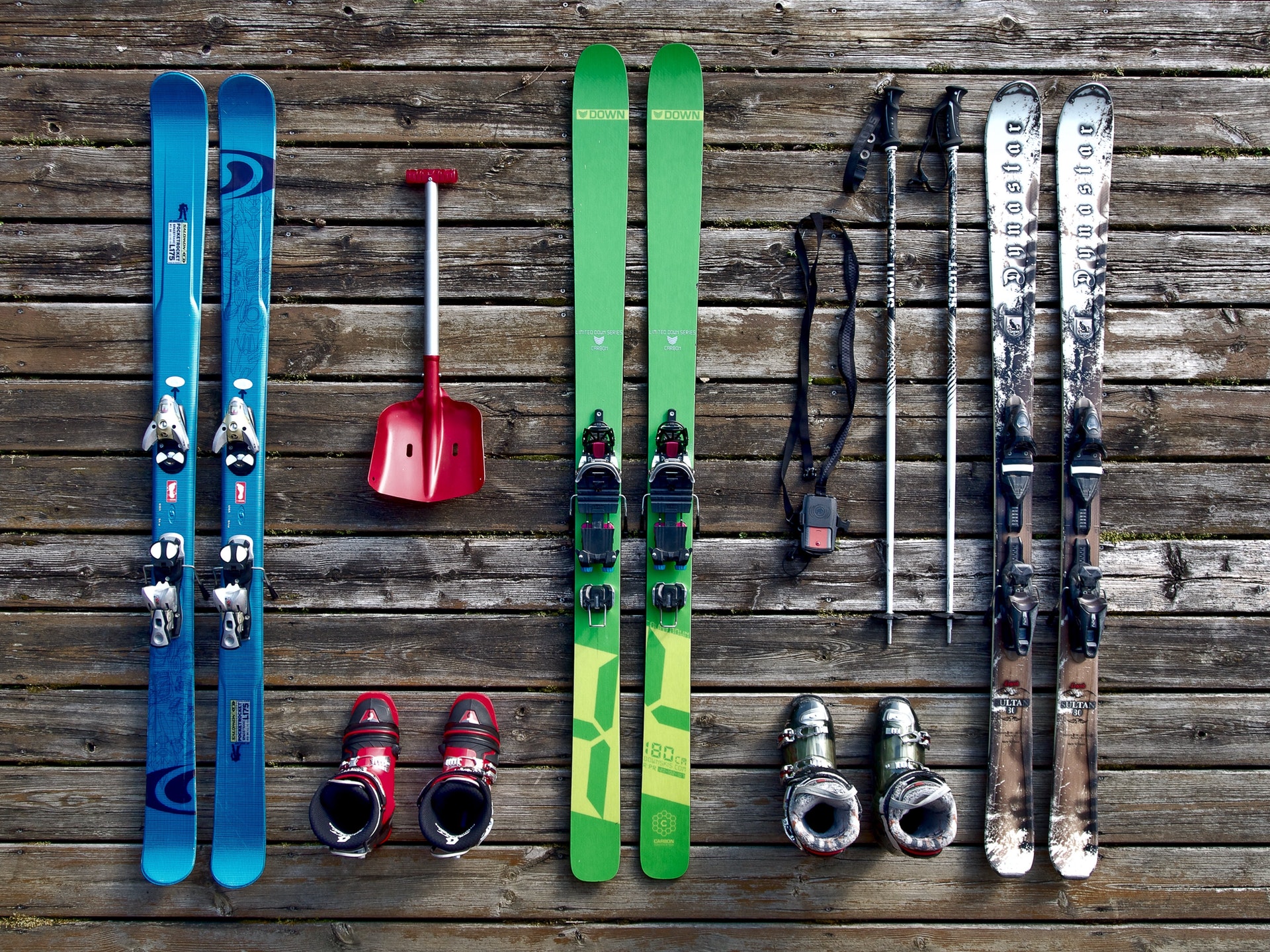a group of skis and boots on a wooden surface