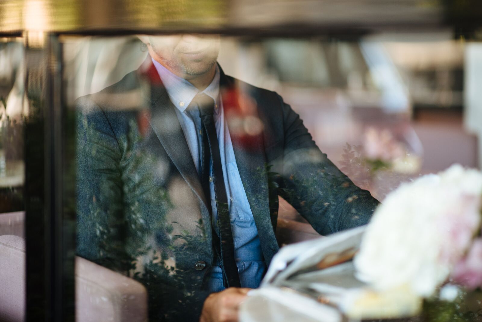 a man in a suit and tie reading a newspaper