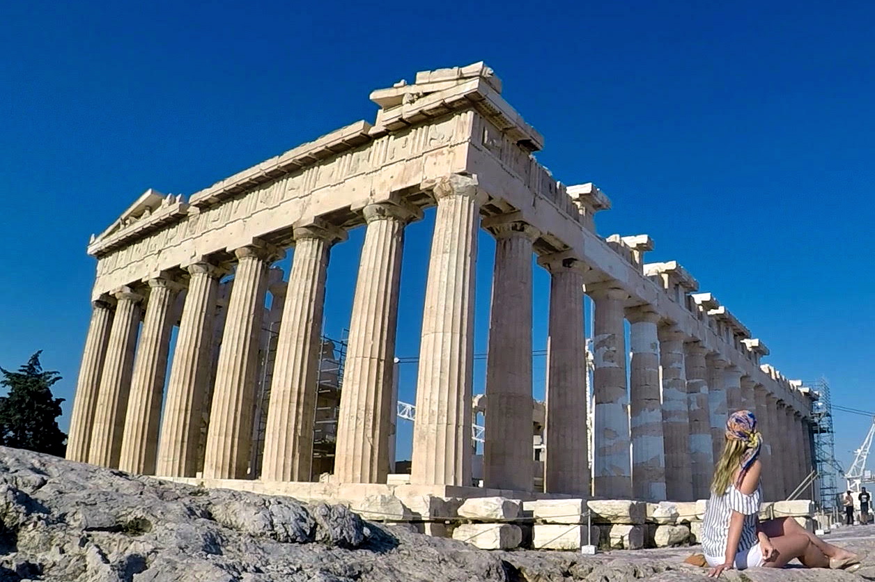a woman standing in front of Parthenon