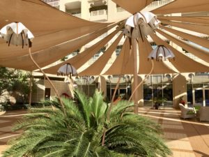 a large shade structure with a palm tree