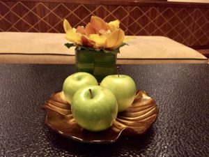 a plate of apples and a vase of flowers