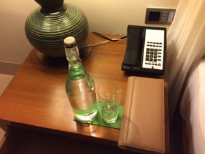 a glass bottle and a phone on a table