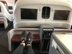 a person's legs on a seat in an airplane