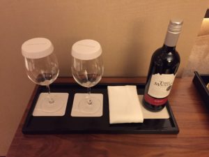 a wine bottle and two wine glasses on a tray