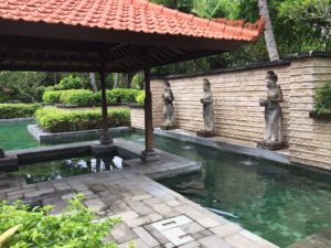 a pool with statues and a red roof
