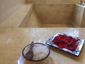 a bowl of rice and a plate of red rose petals