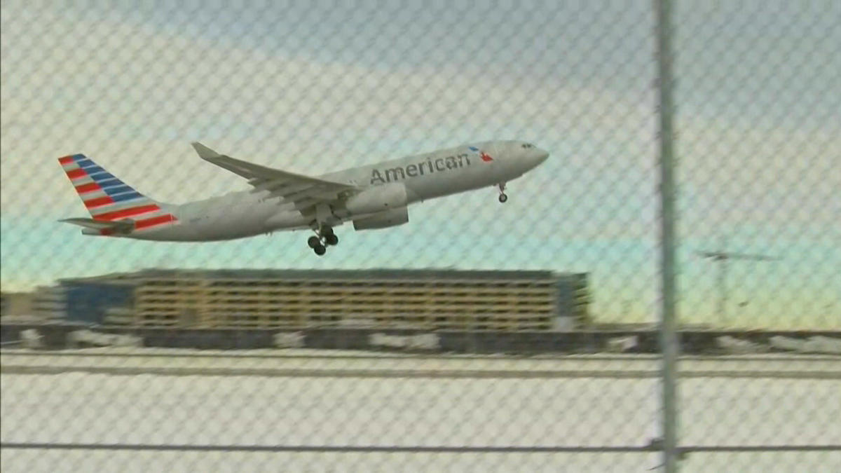 a plane flying over a fence