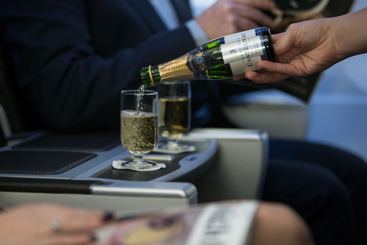 a person pouring a glass of champagne into a glass