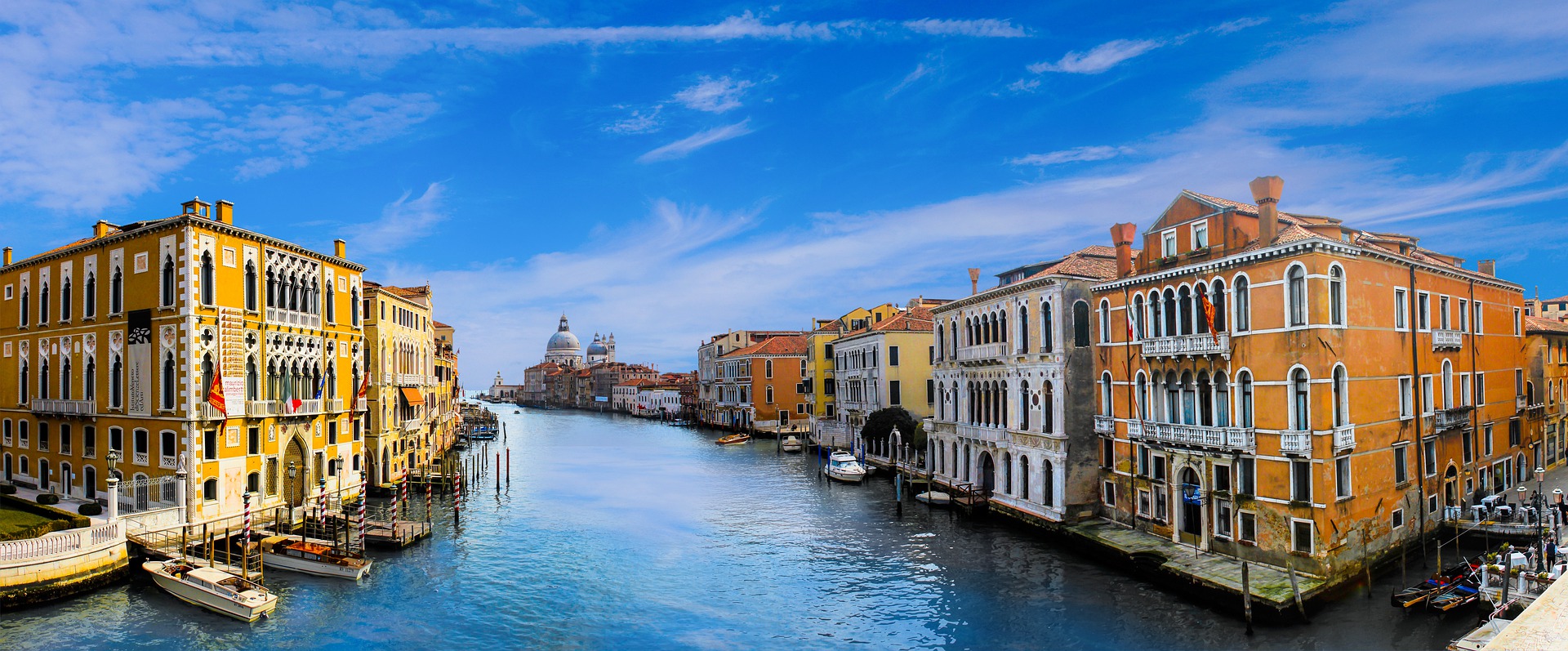 a water way with buildings and boats with Grand Canal in the background