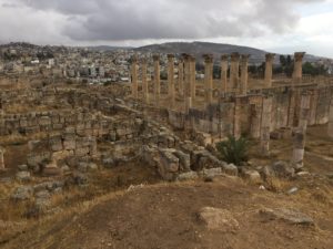 a stone ruins with a city in the background