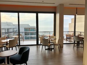 a room with a balcony and tables and chairs