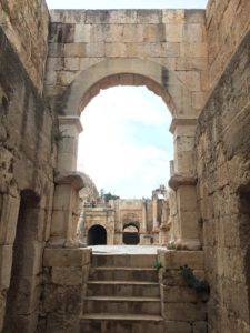 a stone archway with steps leading to a building