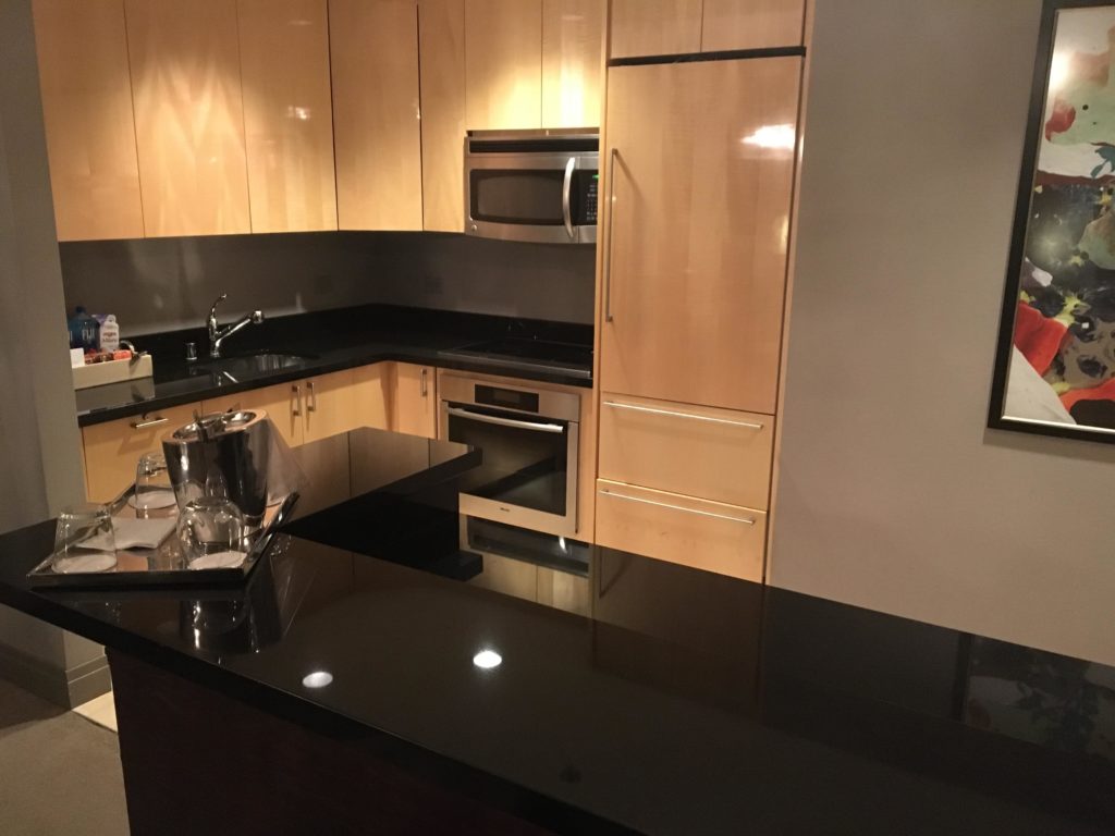 a kitchen with black counter tops and wooden cabinets