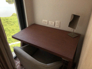 a desk with a lamp and a chair