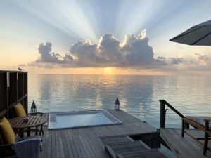 a deck with a hot tub and a body of water