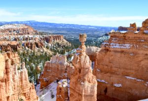 a rock formation with snow on it with Bryce Canyon National Park in the background