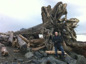 a man standing in front of a large piece of wood