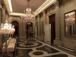 a hallway with chandeliers and marble floor