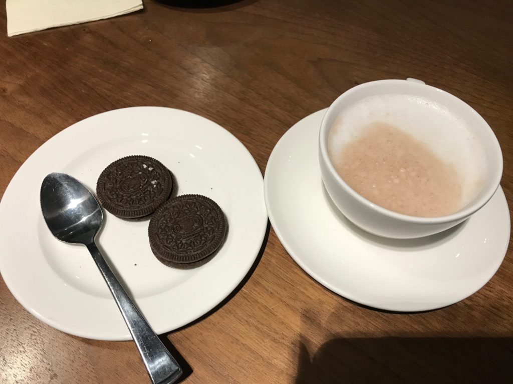 a plate of coffee and cookies on a table