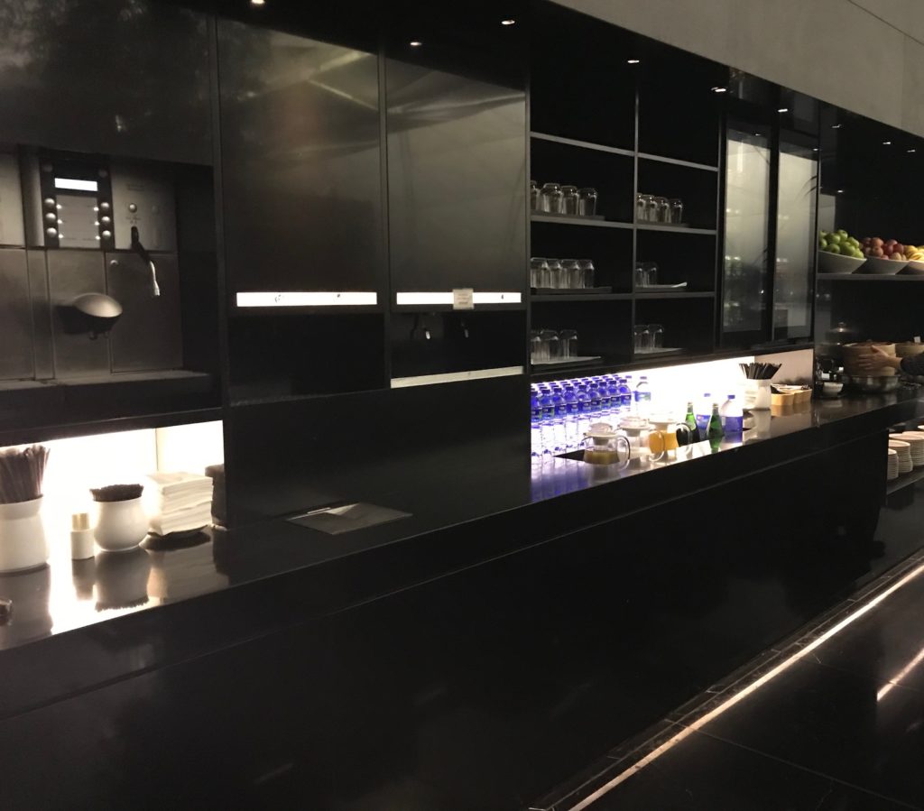 a black counter with shelves and bottles