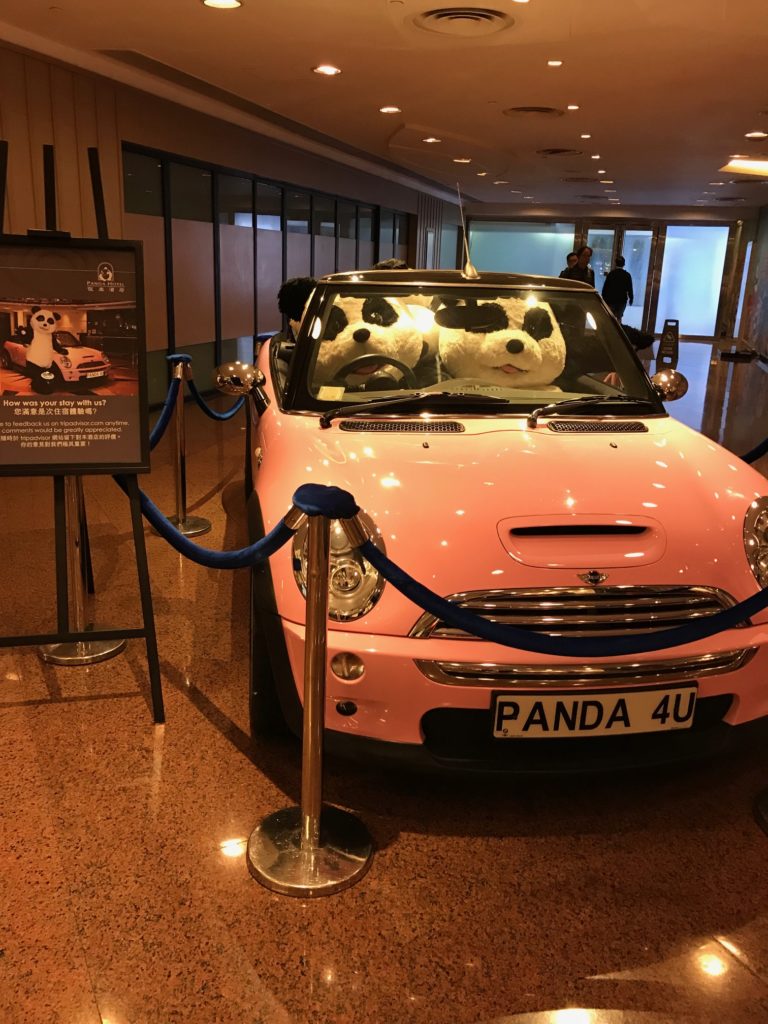 a pink car with stuffed pandas in the front