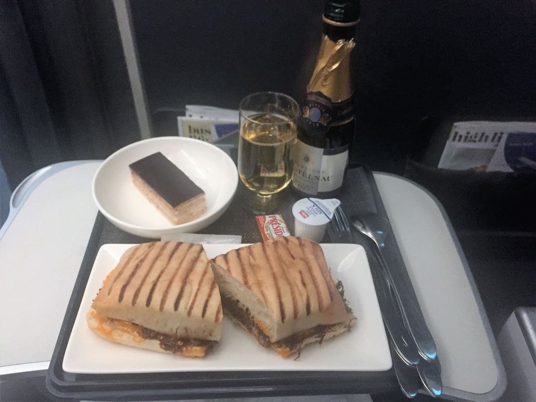 a plate of food and a glass of champagne on a tray