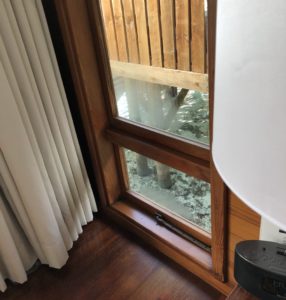 a window with a wood frame and a wood floor