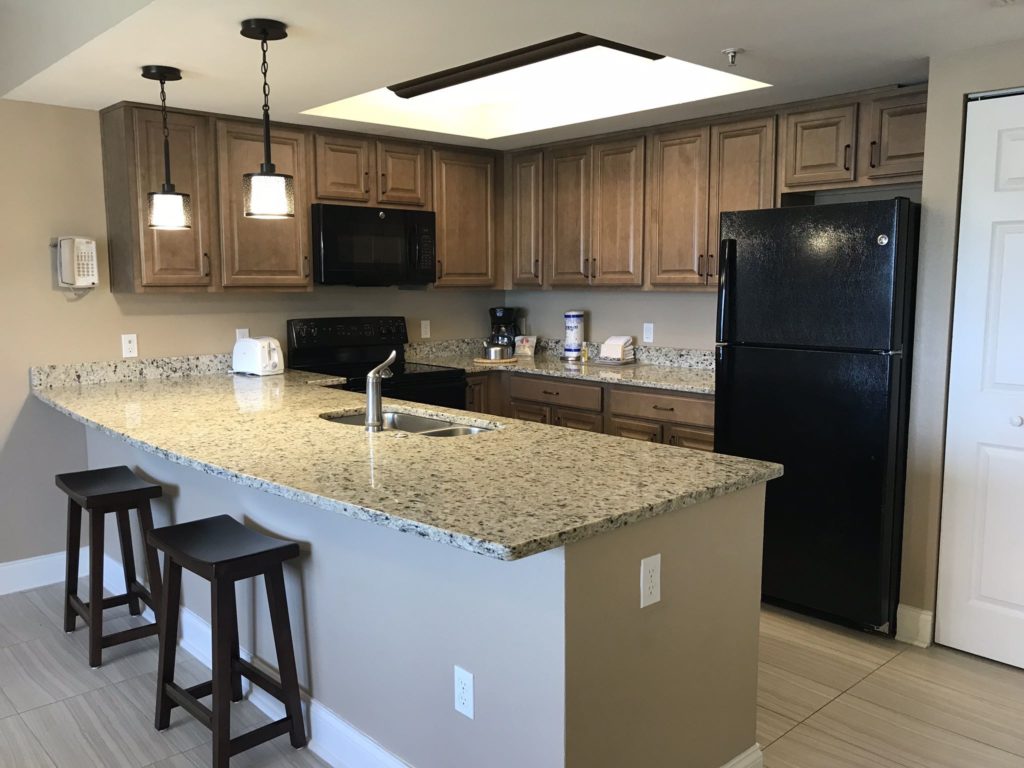 a kitchen with granite counter tops and a black refrigerator