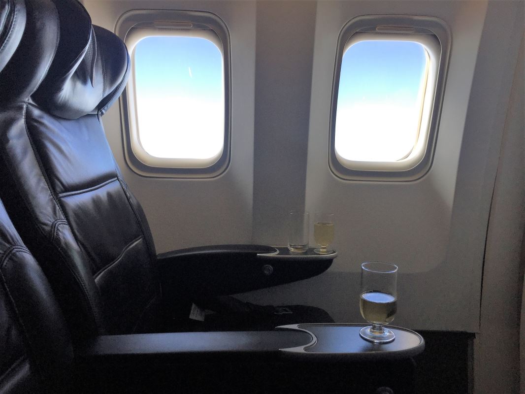 a glass of wine on a table in a plane