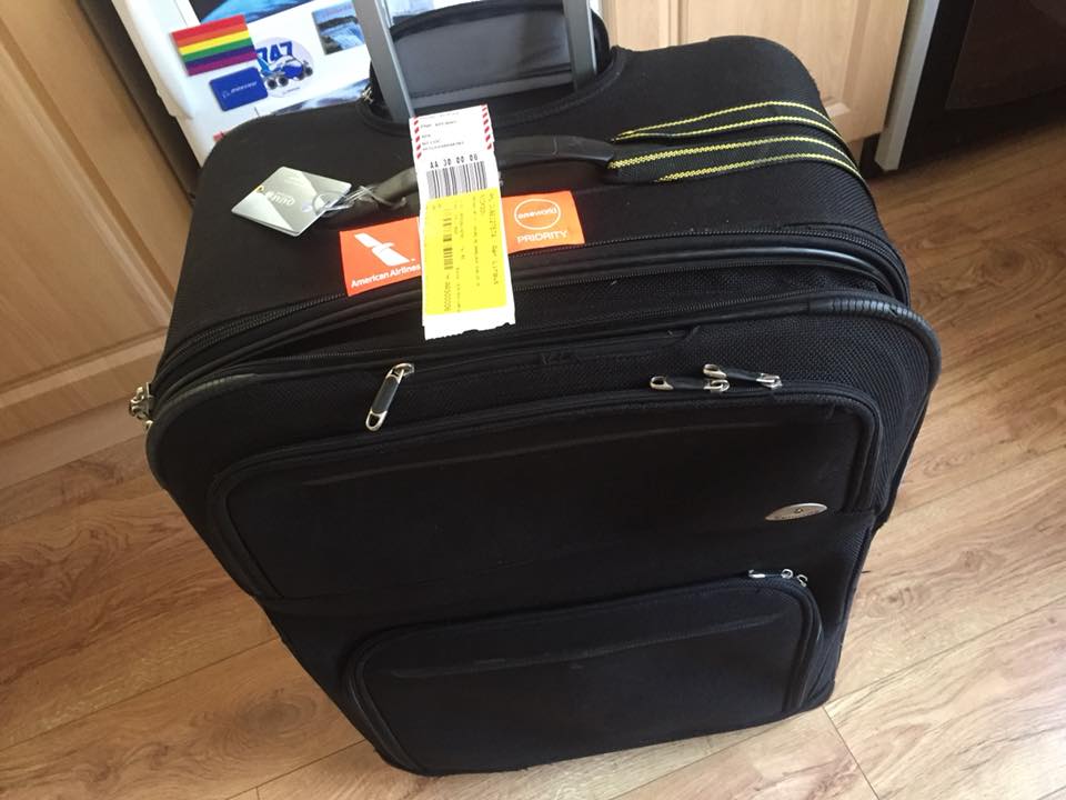 a black suitcase with a yellow tag on top