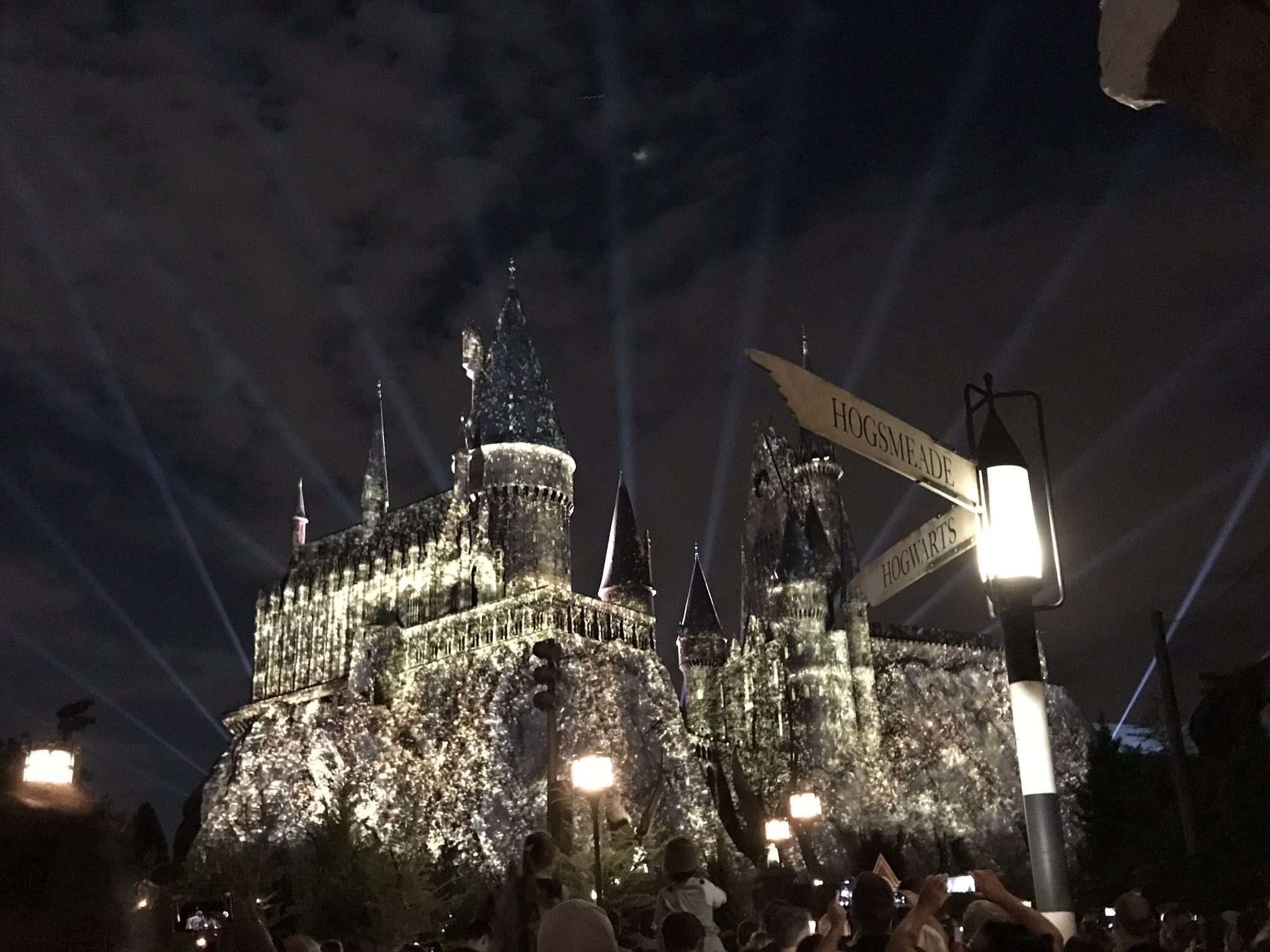 a castle with lights and people watching