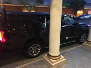 a black van parked next to a white pillar