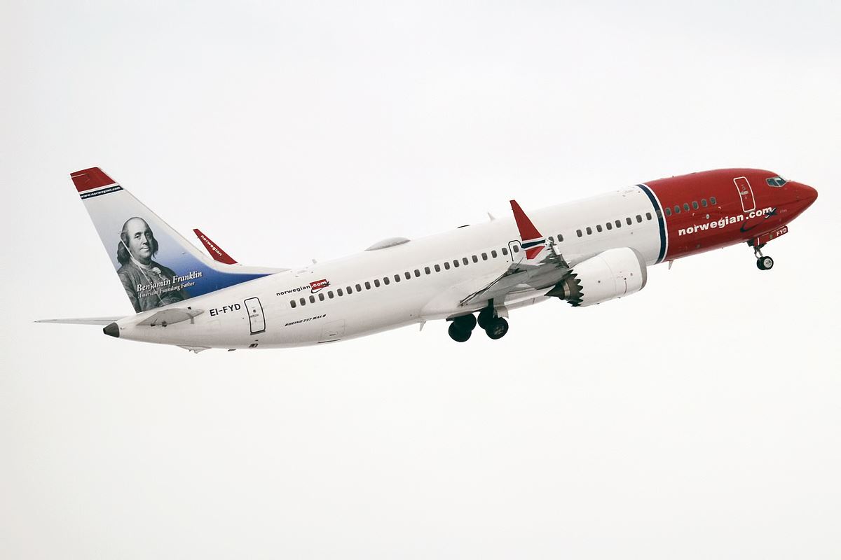 a white airplane with red and blue tail and a picture of a man in the sky