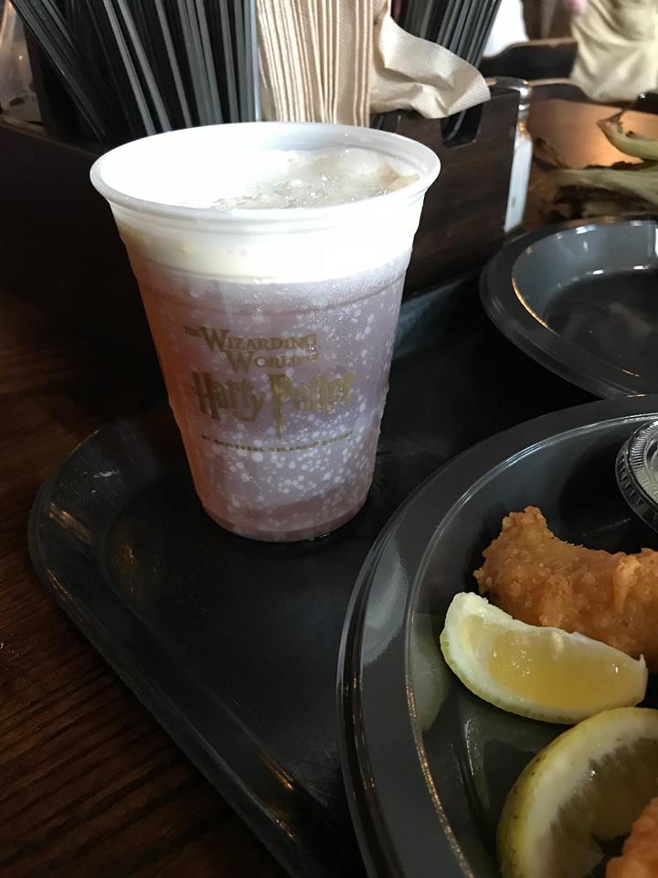 a plastic cup with a drink and a plate of food