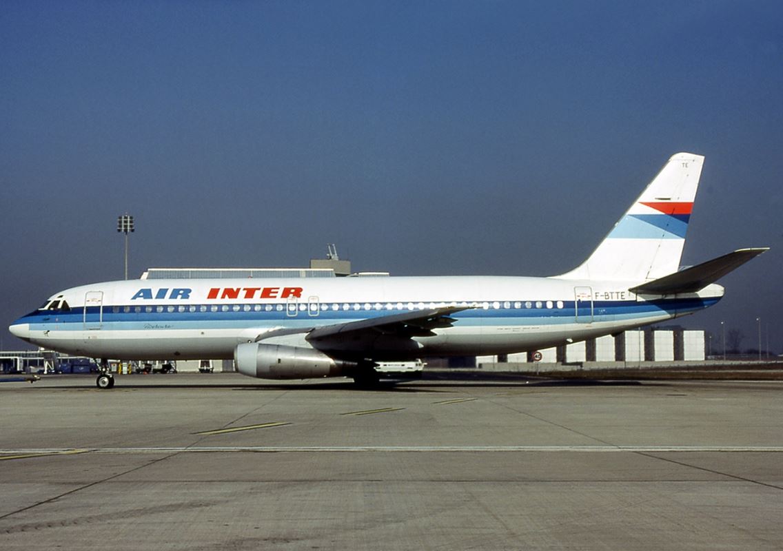 a white and blue airplane on a runway