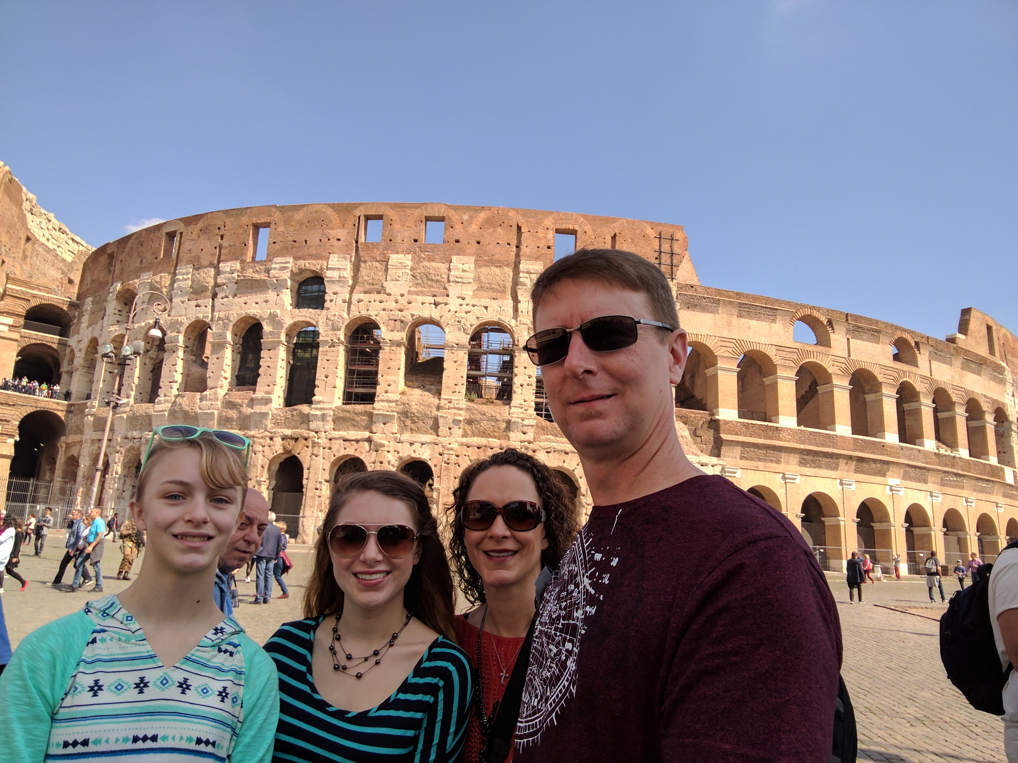 a group of people posing for a photo in front of a large stone structure