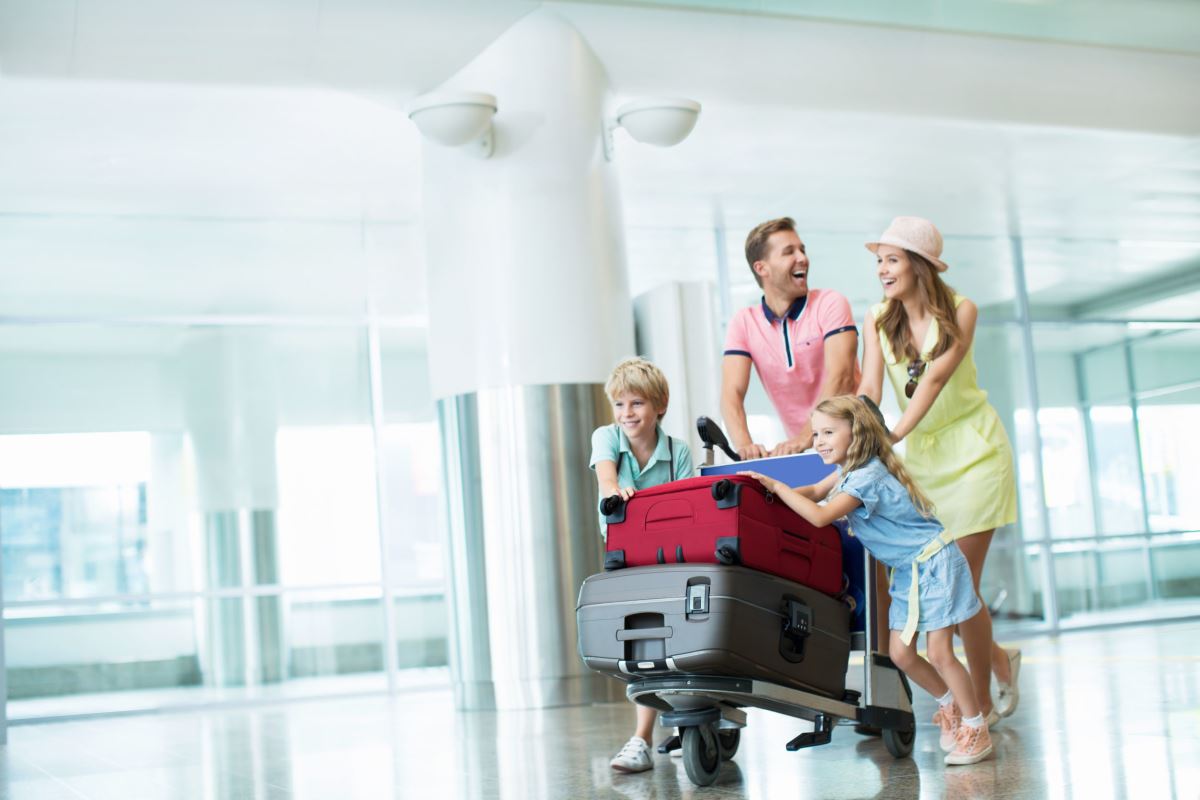 a family pulling luggage in a hallway