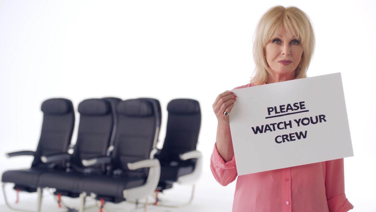 a woman holding a sign in front of chairs