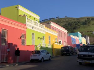 a colorful buildings with cars parked on a street