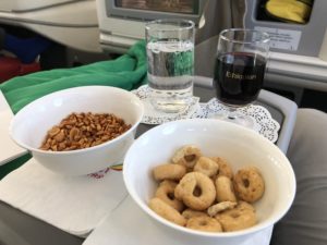 a bowl of cereal and a glass of wine on a tray