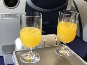 two glasses of orange juice on a tray
