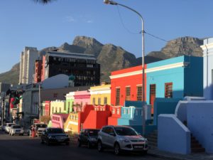 a street with colorful buildings and mountains in the background