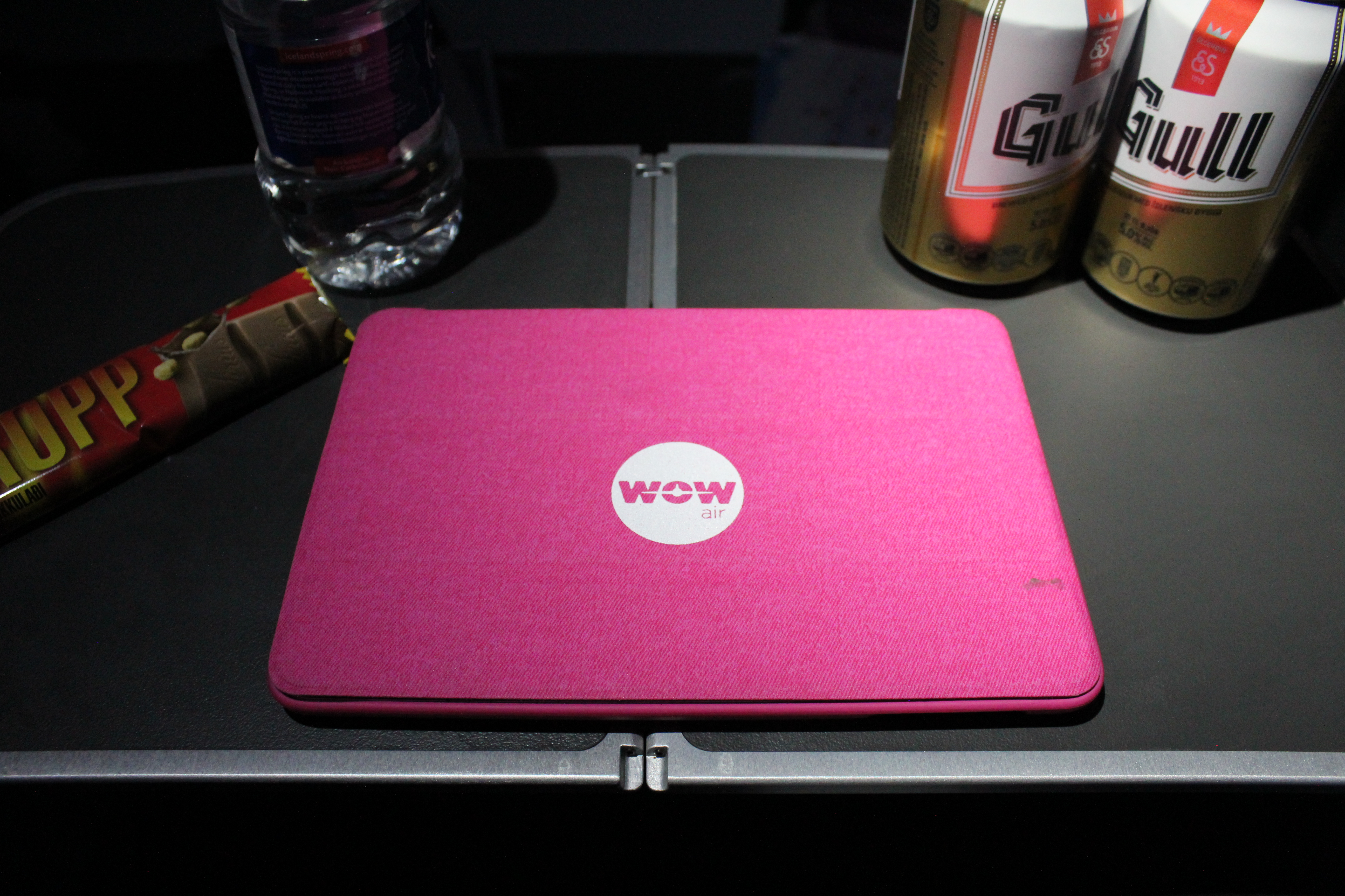 a pink laptop on a black surface