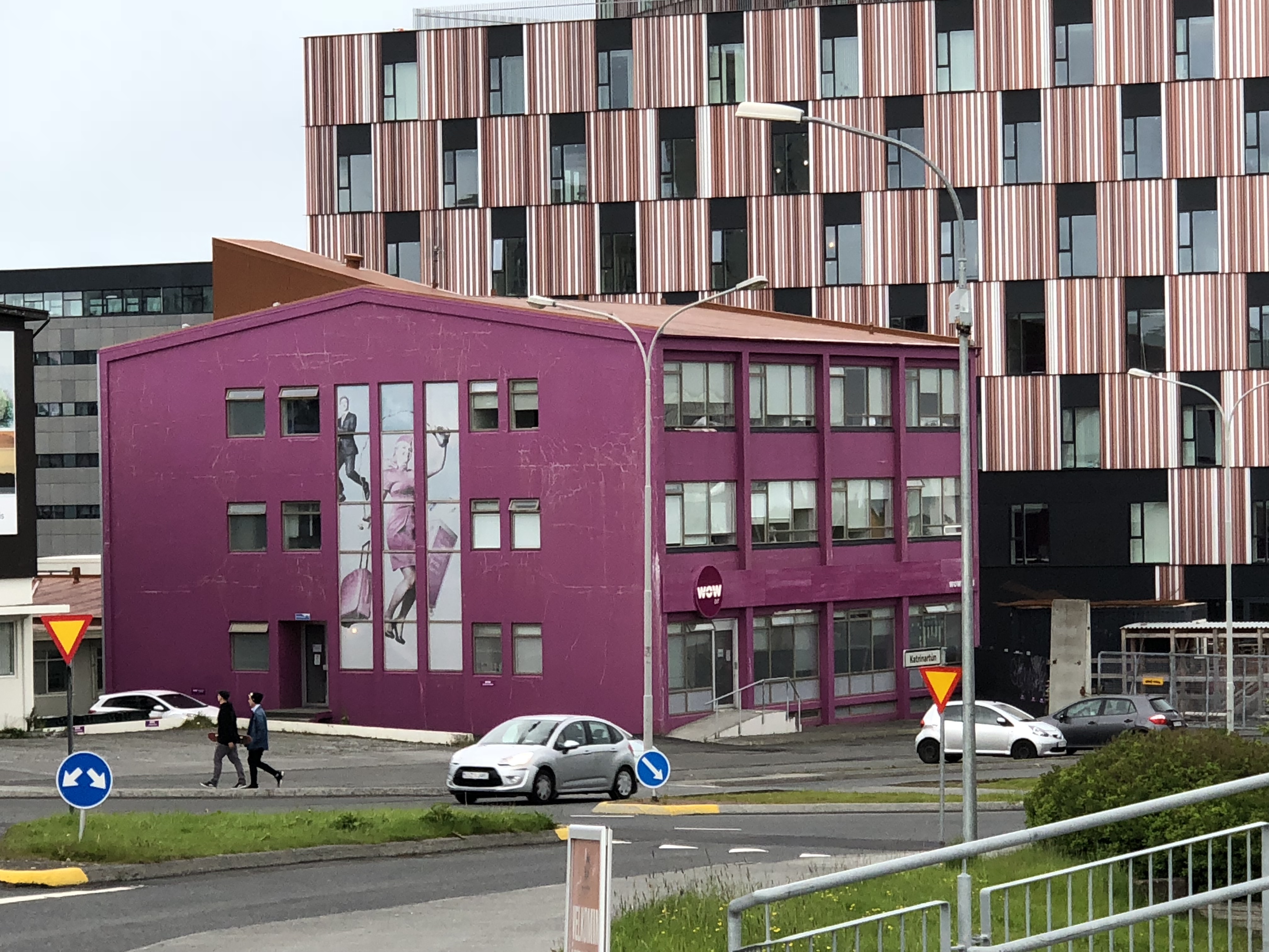 a purple building with a couple of cars in front of a building