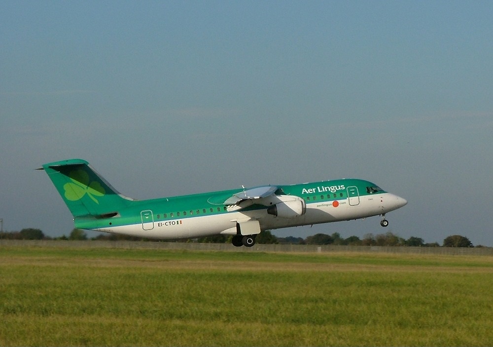 a green and white airplane taking off