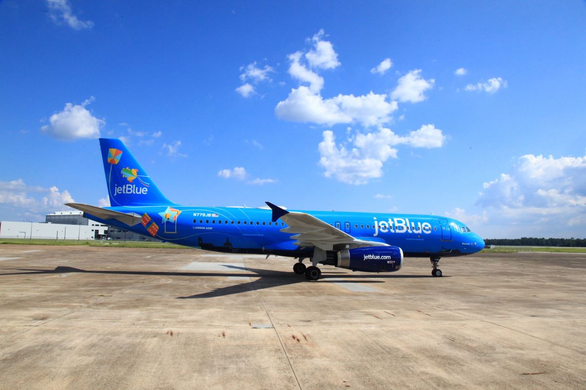 a blue airplane on a runway