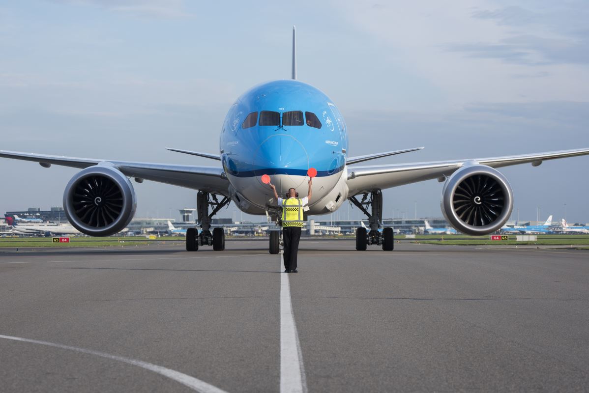 a man standing next to a blue and white airplane