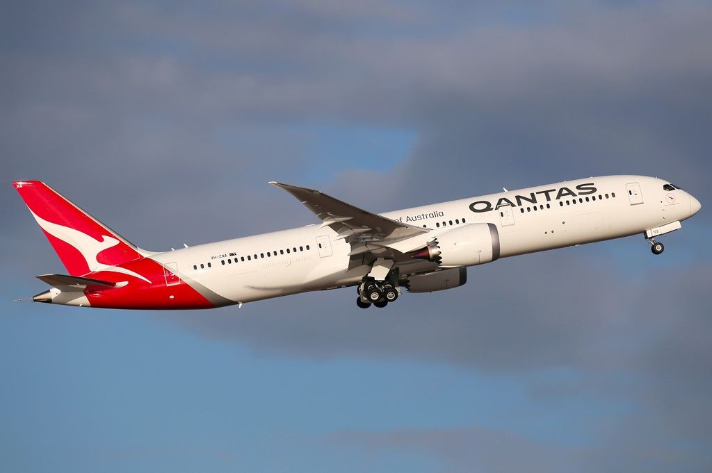 a white and red airplane flying in the sky